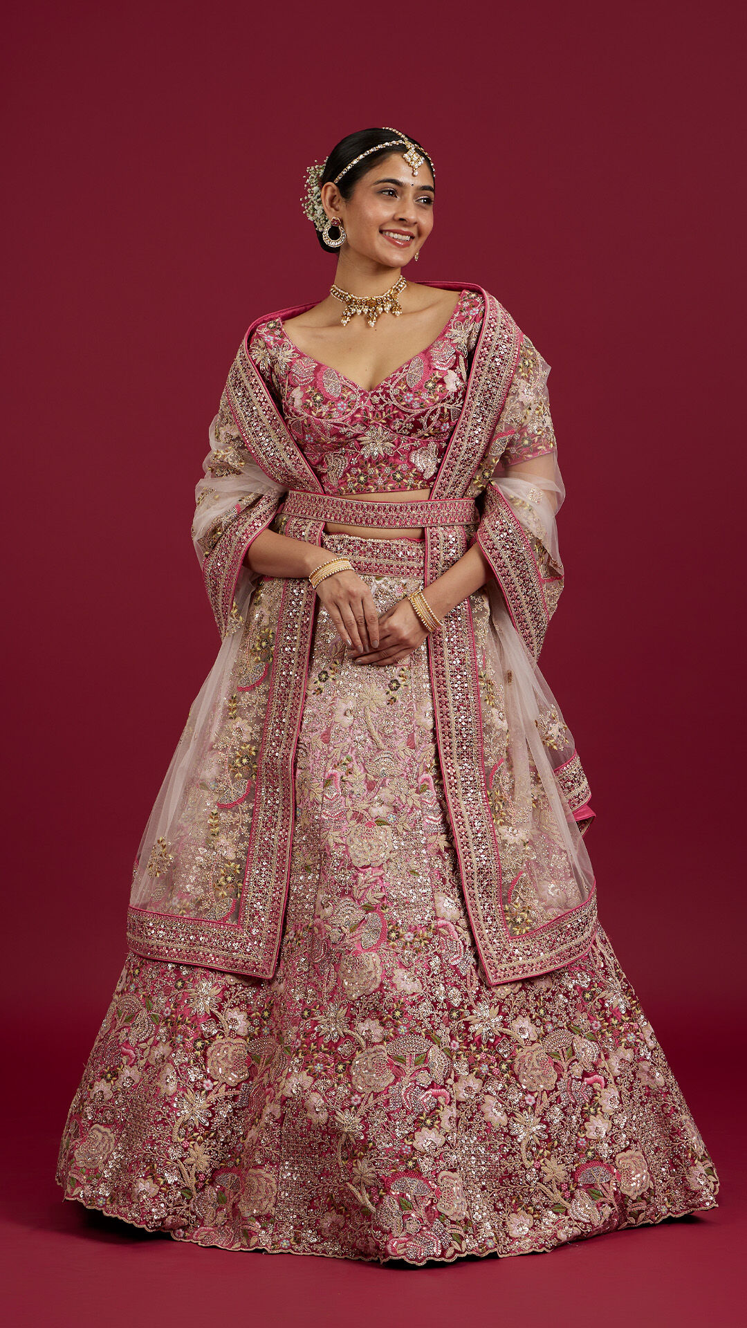Pink lehenga with floral prints styled for an elegant bridal appearance